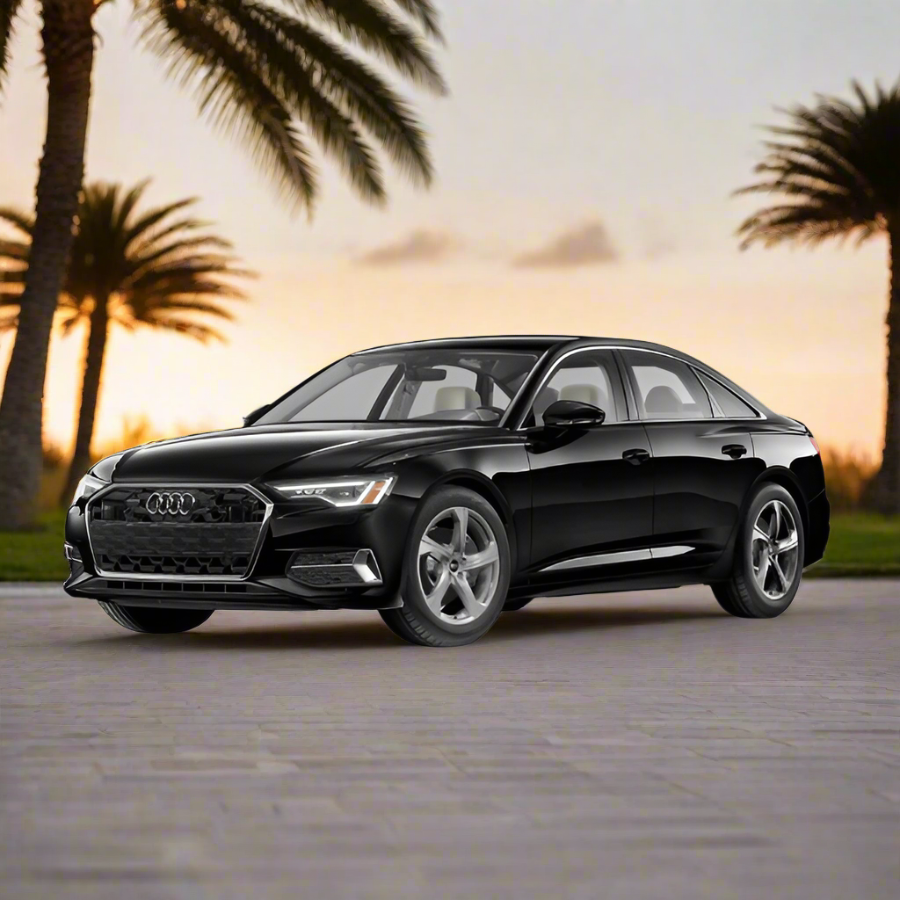 Black Audi car on a road with palm trees and sunset in the background